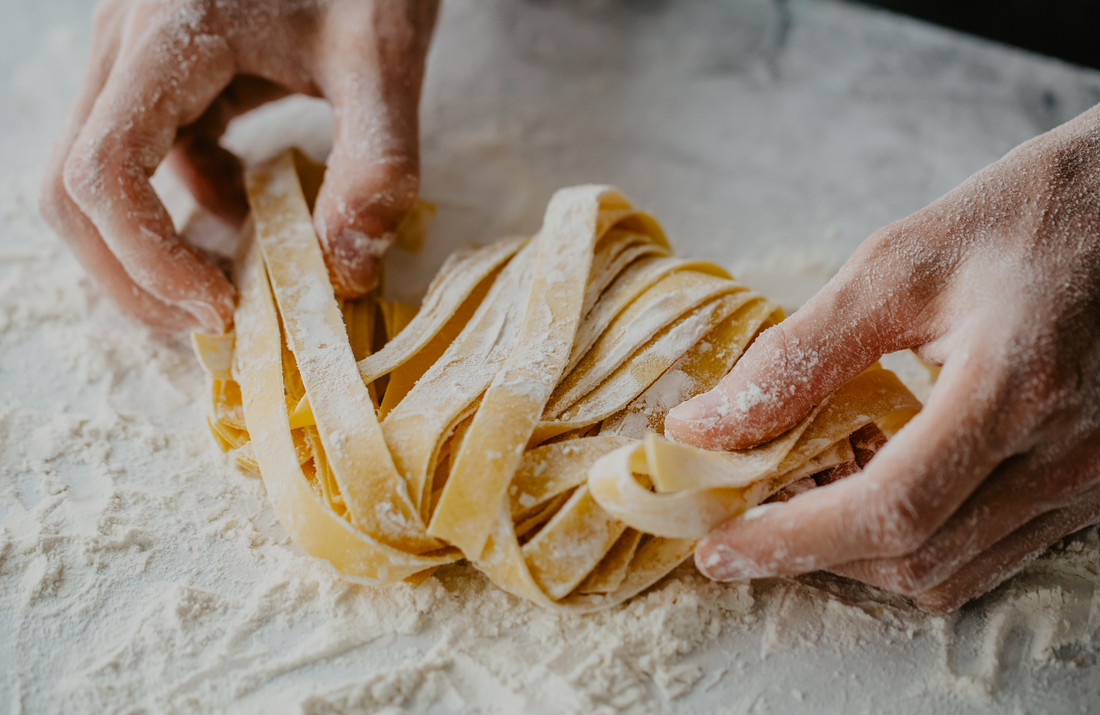 Hands making homemade pasta with flour 