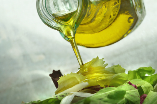 Olive oil being poured onto a salad