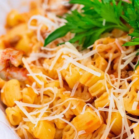 Close up of Crawfish Cajun Pasta made with Dagostino Smooth Tomato Sauce, garnished with cheese and parsley.