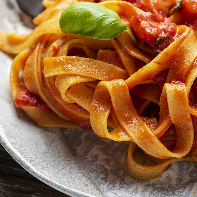 Close up of a plate filled with fettuccine pasta, topped with Dagostino Chunky Tomato Sauce.
