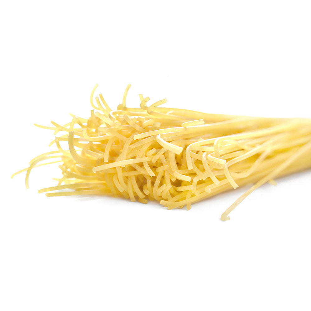 Close up of a pile of dried Dagostino Spaghetti Pasta against a white background.