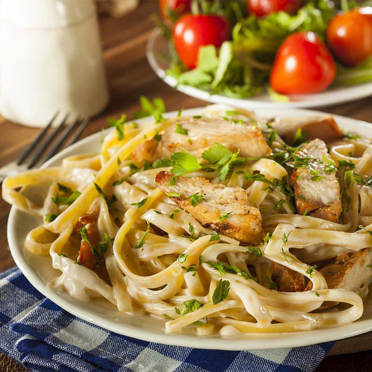 Close up of a white plate filled with chicken fettuccine alfredo
